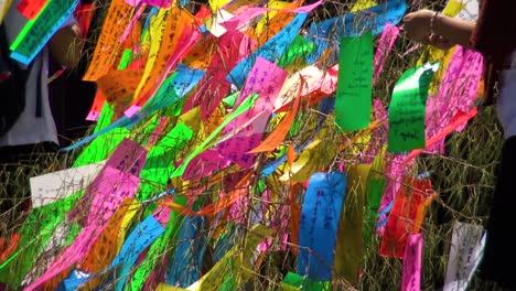 People-bunding-wishes-on-paper-to-a-tree-in-Zozo-ji-Temple