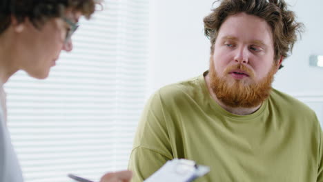 female doctor listening to patient and taking notes