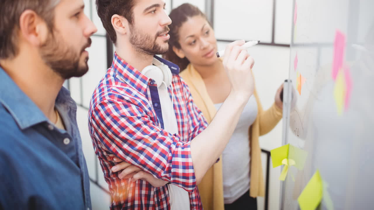 video de creativos diversos colegas masculinos y femeninos escribiendo en notas de memoria en la oficina moderna