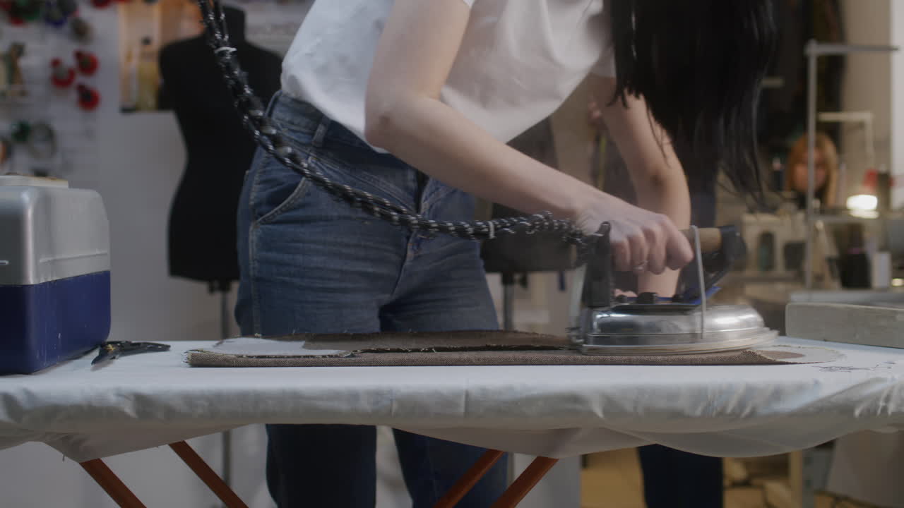 Woman Ironing Fabric in a Tailor Shop