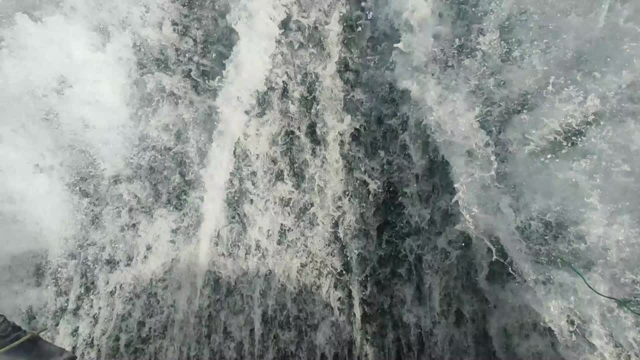 close up of wake of water behind fast moving motor boat in a clear sky day,Blue sea , water surface
