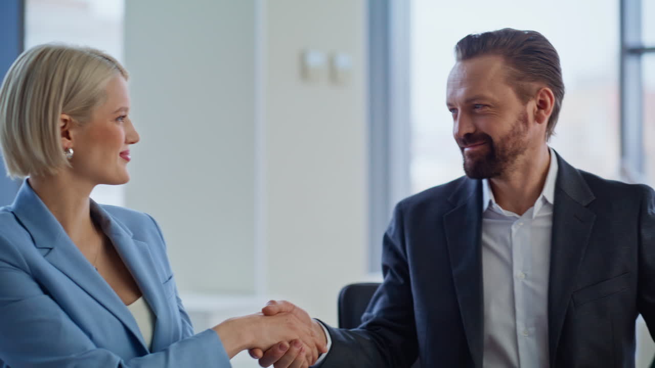 Tæt på startup-ejere, der indgår aftale på kontoret. Forretningspartnere giver hånd.