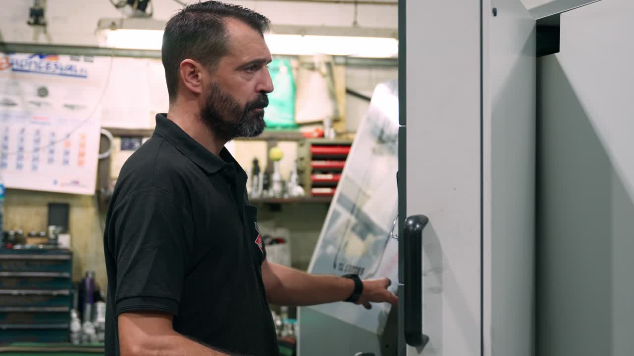Man operating CNC machine in factory