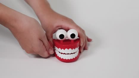 hands interacting with a chattering teeth toy