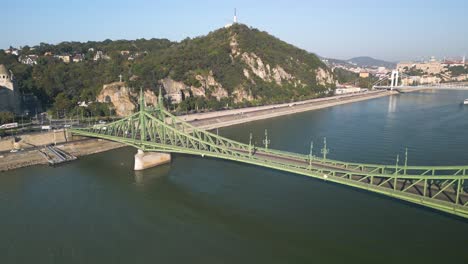 Backwards-Drone-View-of-Green-Freedom-Bridge-in-Budapest-over-the-Danube-River