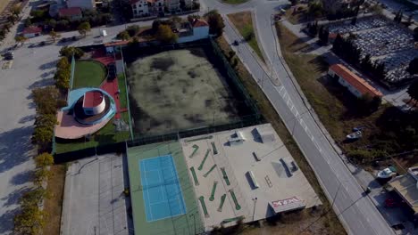 establecimiento aéreo sobre instalaciones deportivas al aire libre y una pequeña ciudad en grecia