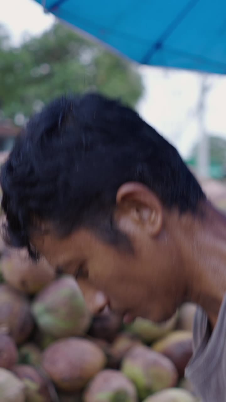 Man selling coconuts at the market