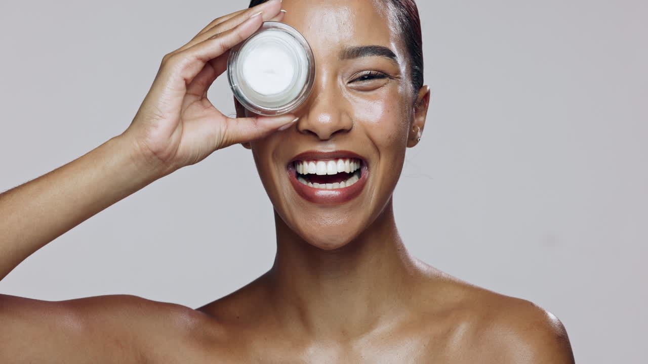 mujer con crema facial delante de su ojo