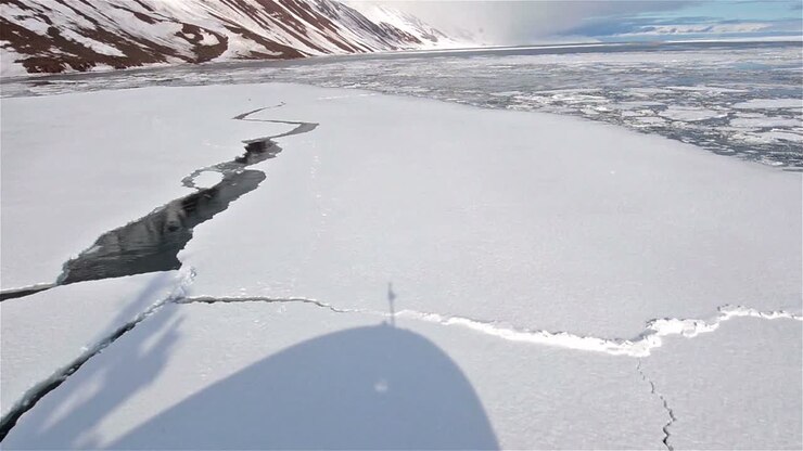 Shadow of a ship moving through sea ice in Lomfjorden in Svalbard Archipelago Norway