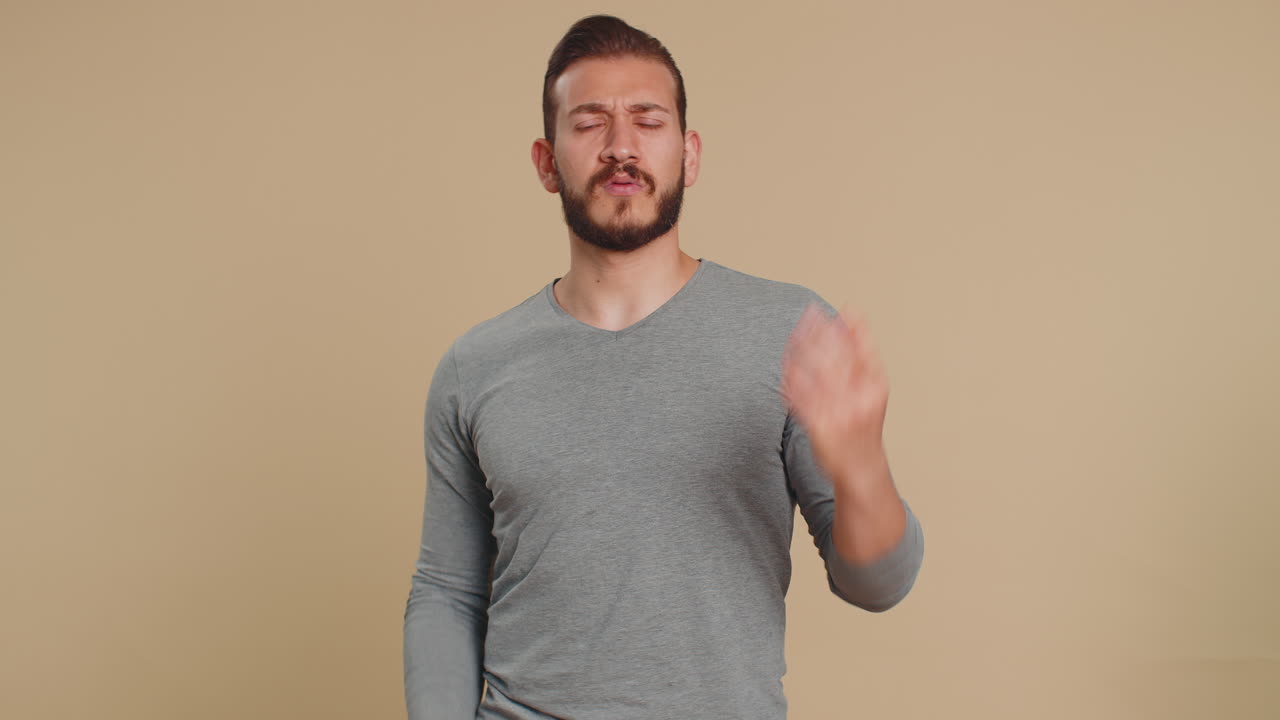 L'uomo cerca di sentire guardando confuso accigliando le sopracciglia tenendo il braccio vicino all'orecchio per una voce più alta chiedendo di ripetere