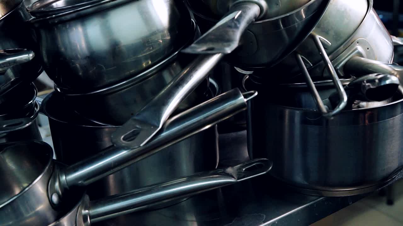 Pots and pans in professional restaurant kitchen. Equipment for cooking. Clean stainless kitchenware. Close-up