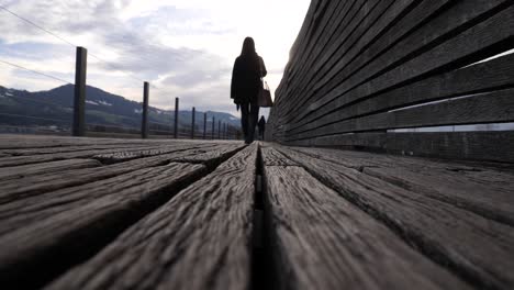 el bloqueo de la cámara se disparó en el suelo de una joven asiática caminando sobre un muelle de madera