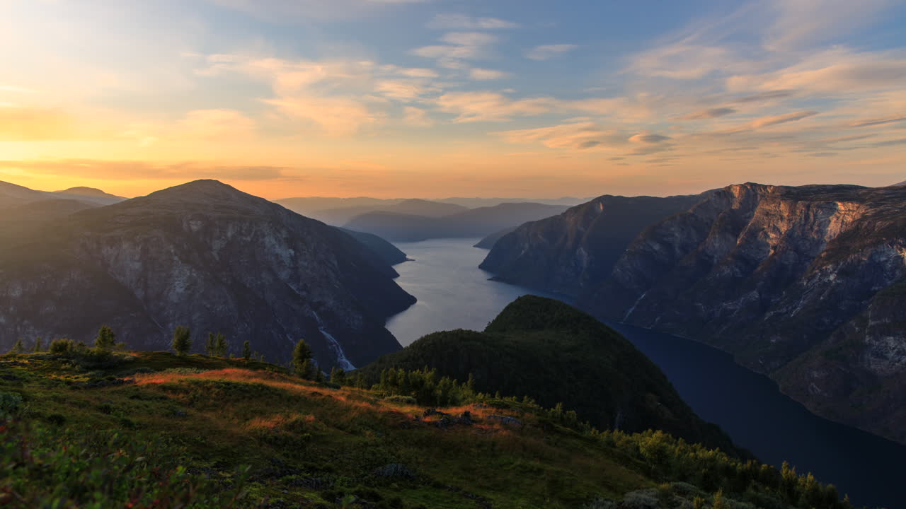 Matahari terbenam yang indah di atas fjord dan pegunungan Norwegia.