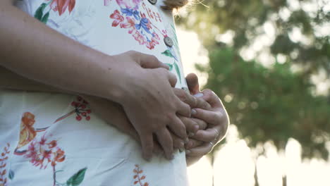 a pregnant couple holding their belly in a floral dress