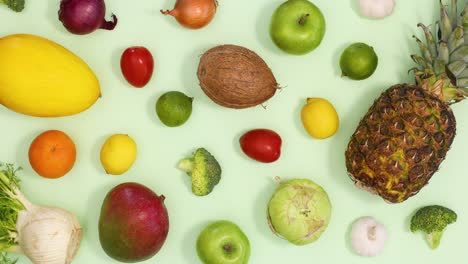 healthy fresh pattern made of moving fruits and vegetables on light green background. stop motion