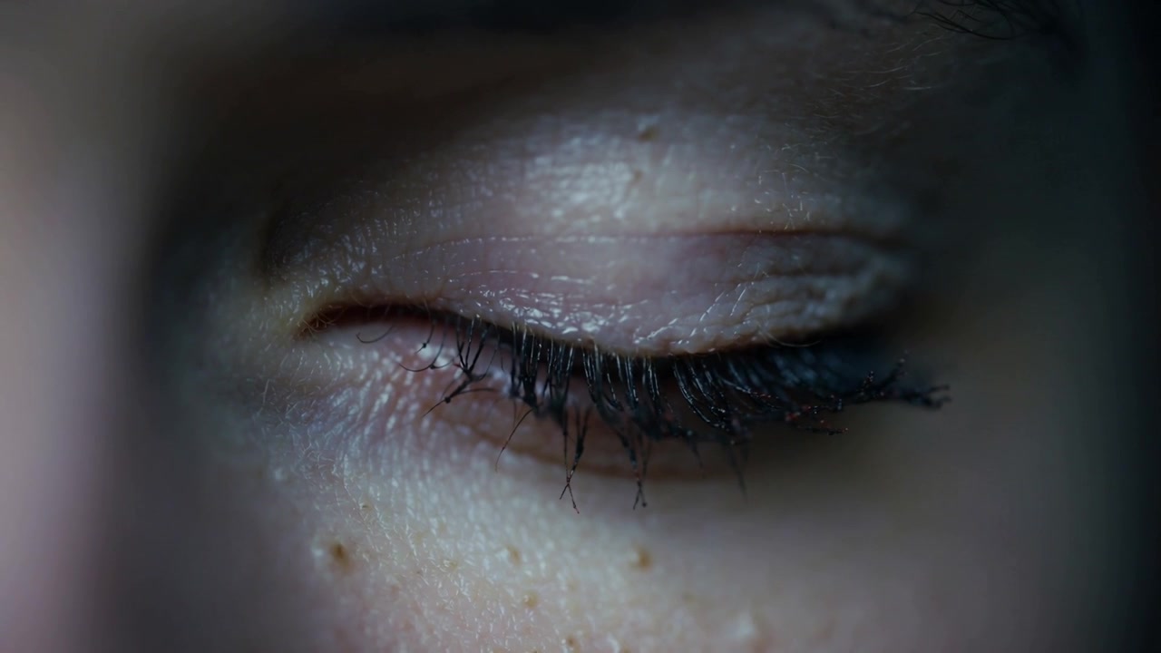 Showing woman's closed eye twitching after minor twitch starting in cool close-up, clumped mascara