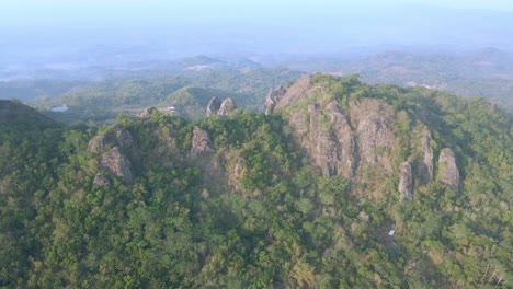 Vista-Aérea-De-La-Montaña-Rocosa-Cubierta-Por-Densos-Bosques