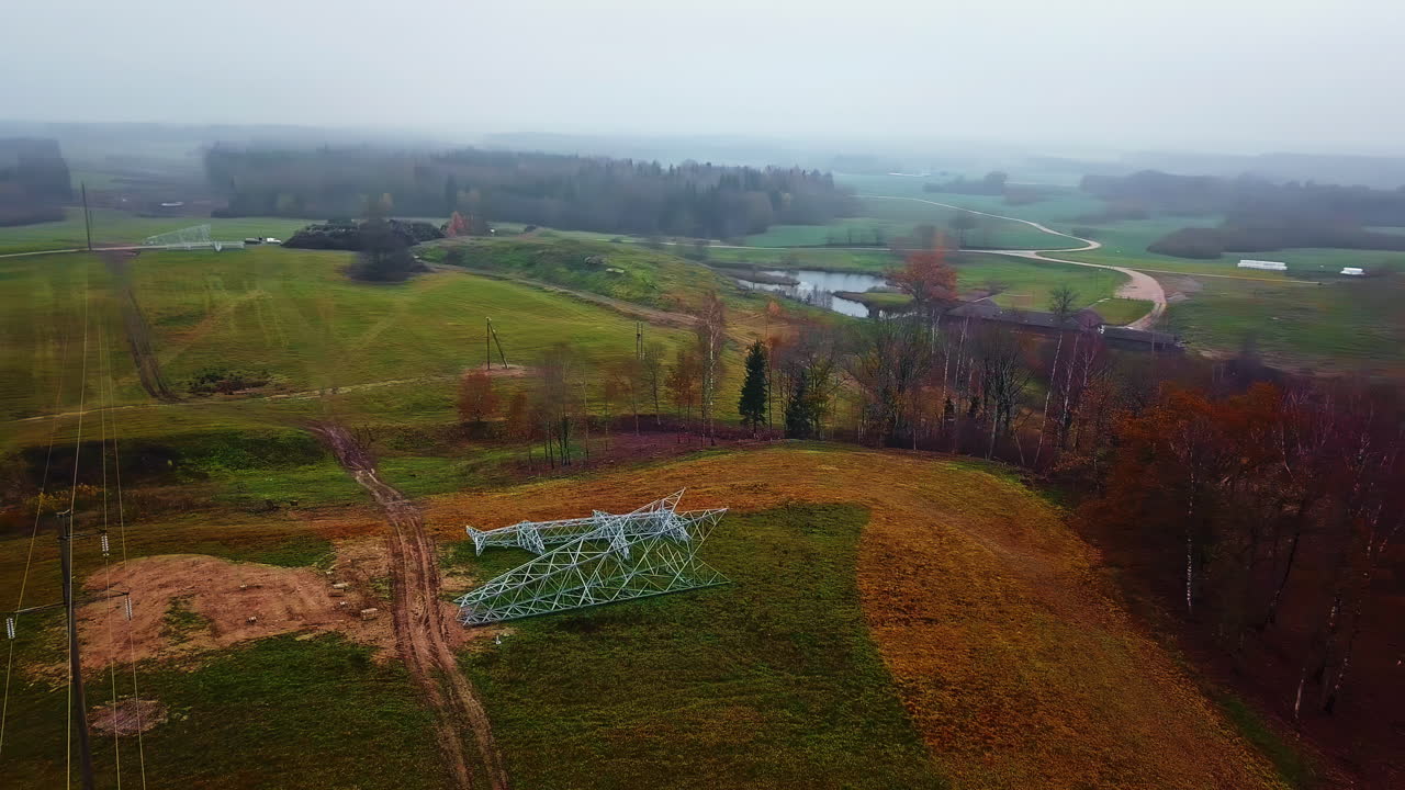 vista aérea rodeando pilones en el suelo, construcción de alambre eléctrico, día de otoño