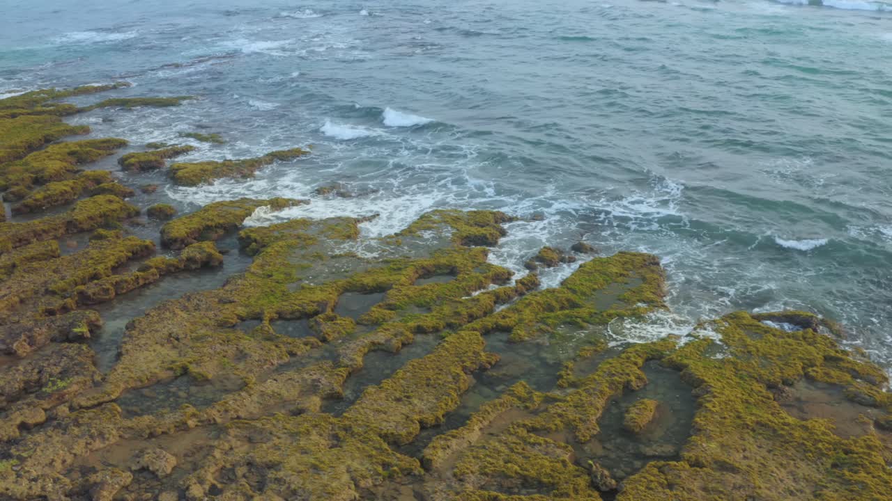 Veduta aerea delle onde sulla spiaggia di Bai Bang, con rocce coperte di muschio, provincia di Phu Yen, Vietnam centrale.