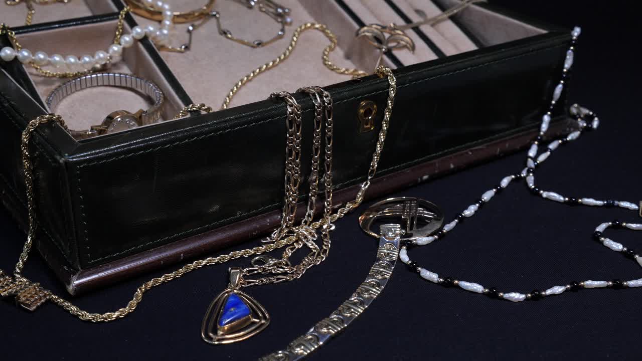 открытая шкатулка с драгоценностями, разбросанными вправо - может быть ограбление