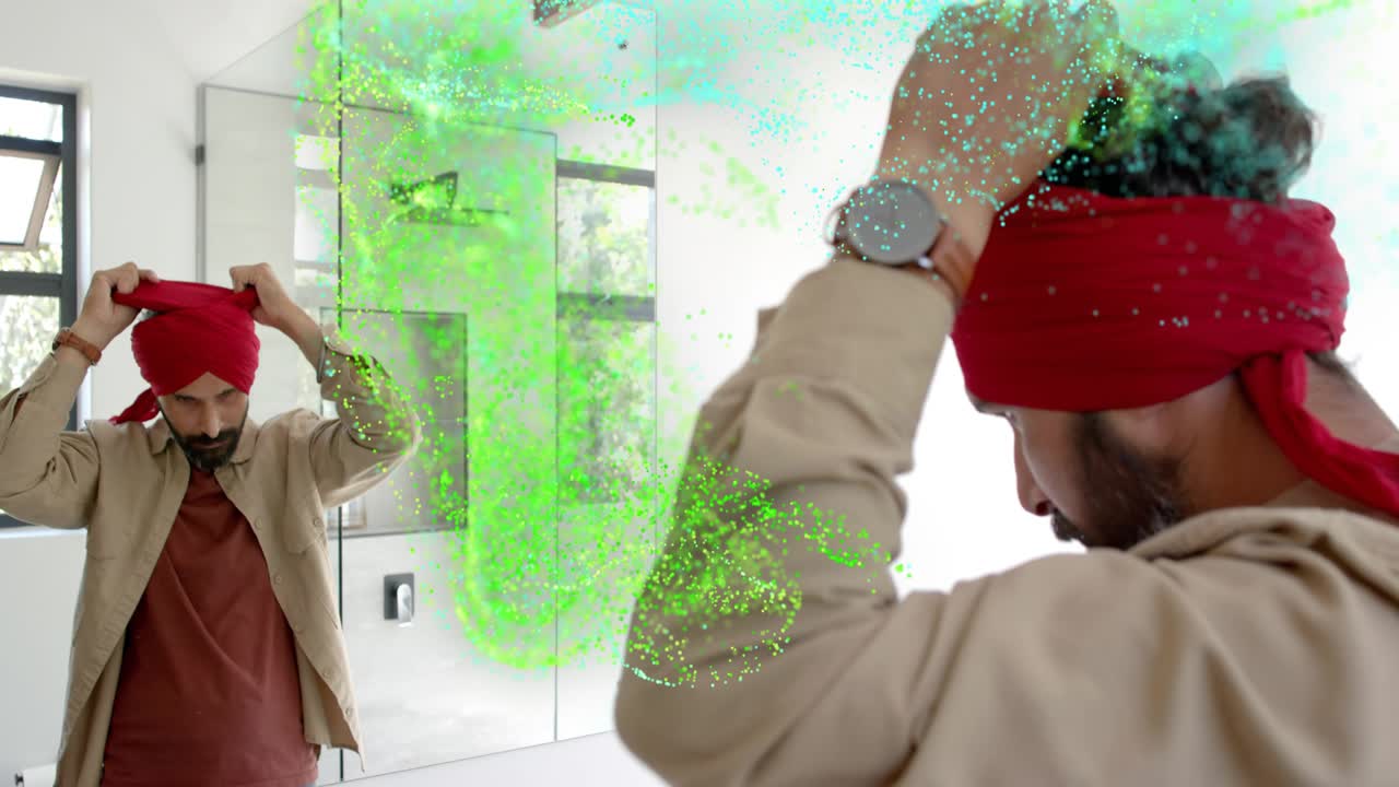 Man looking into mirror tying red turban for grooming, teal plumes expanding over right side