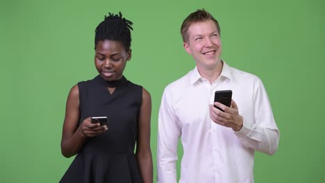two young multi-ethnic business couple using phone together