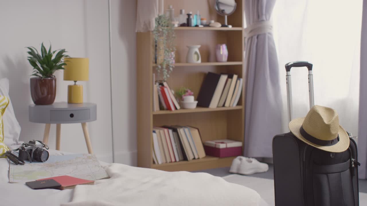 카메라 지도 와 여권 을 침대 에 두고 여름 휴가 를 위해 준비 된 가방 을 집 에 두고 있다