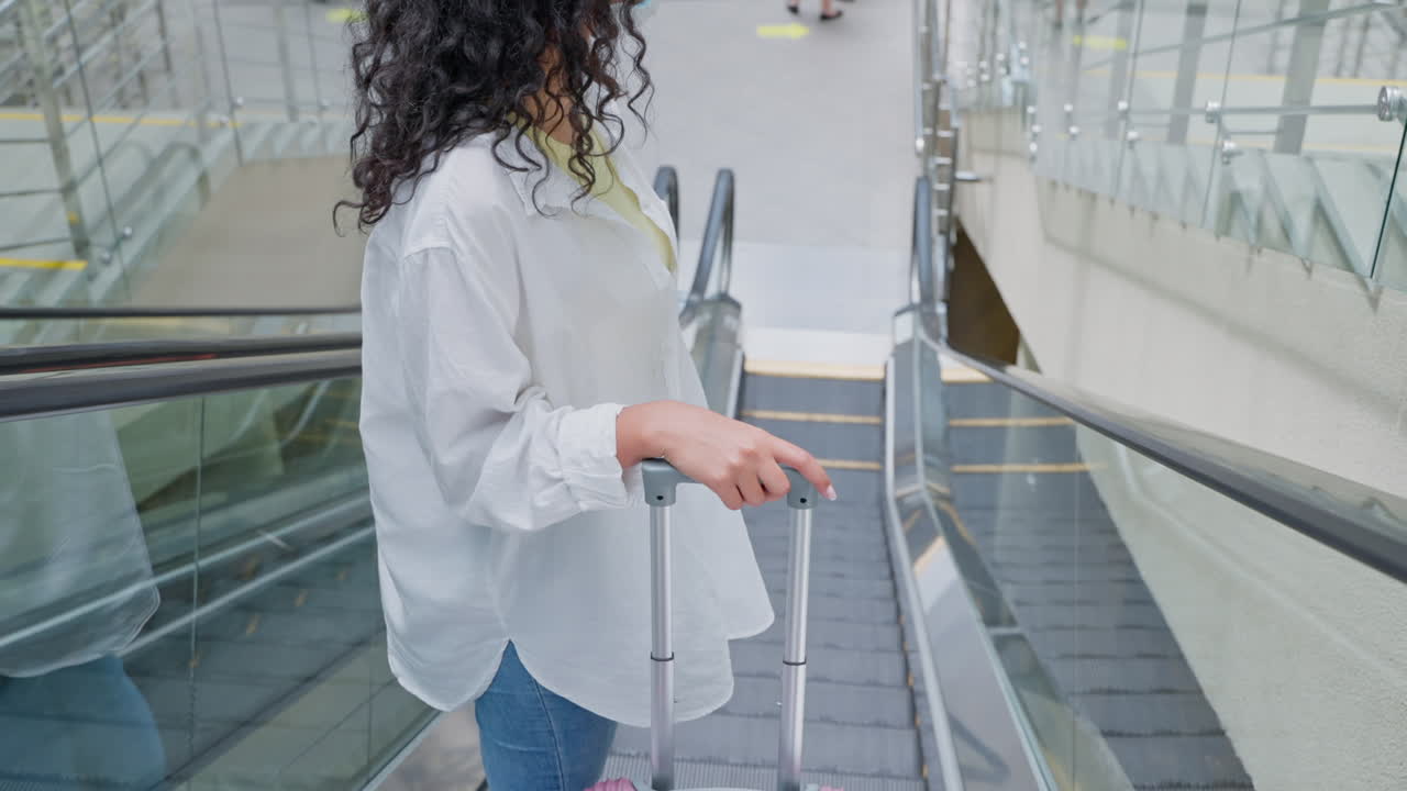 공항 에스컬레이터 에 짐 을 들고 있는 여자