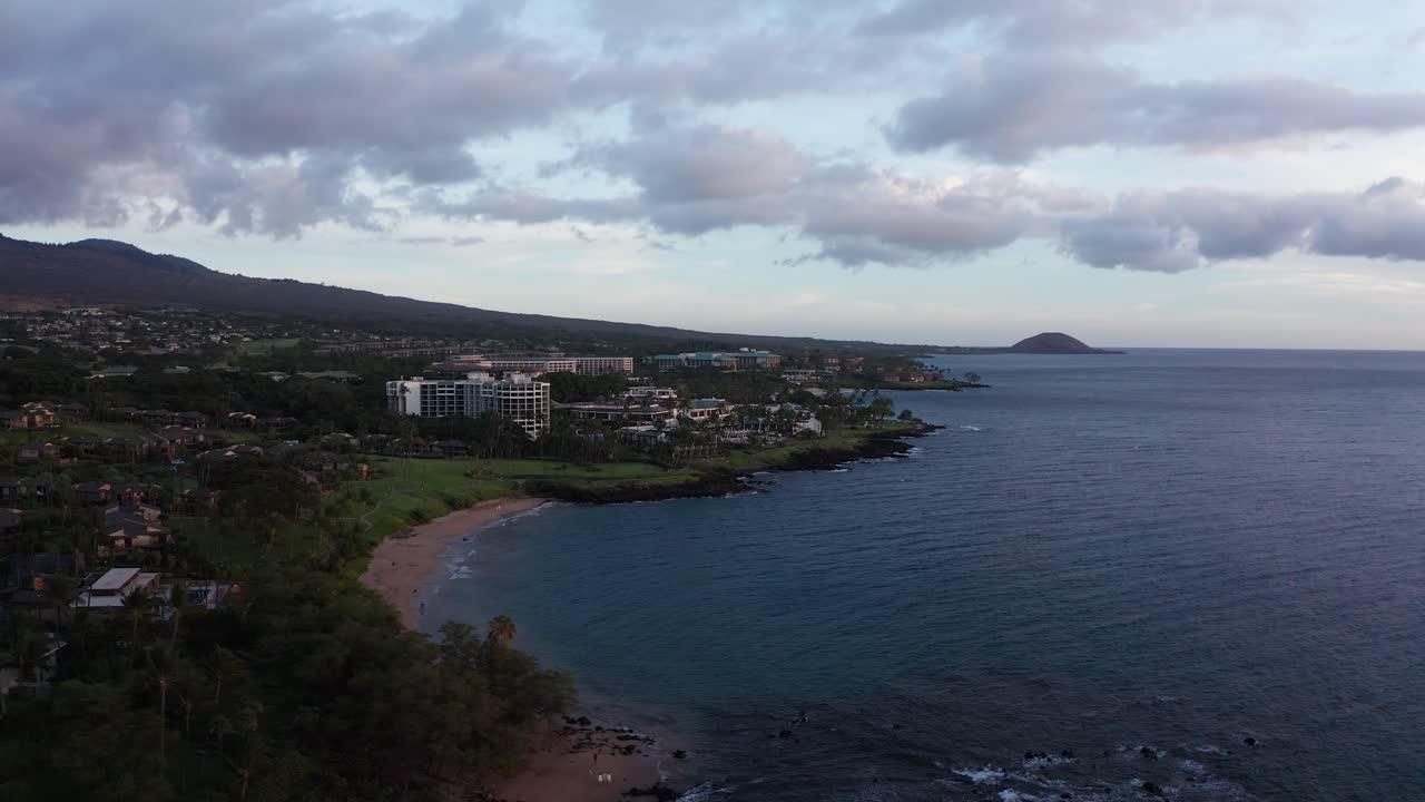 Low panning aerial shot of luxury beach resorts at Wailea during sunset in South Maui, Hawai'i