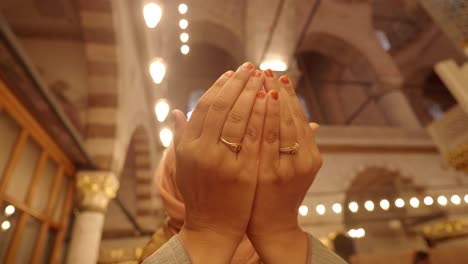 close up of a person's hands in prayer in a mosque