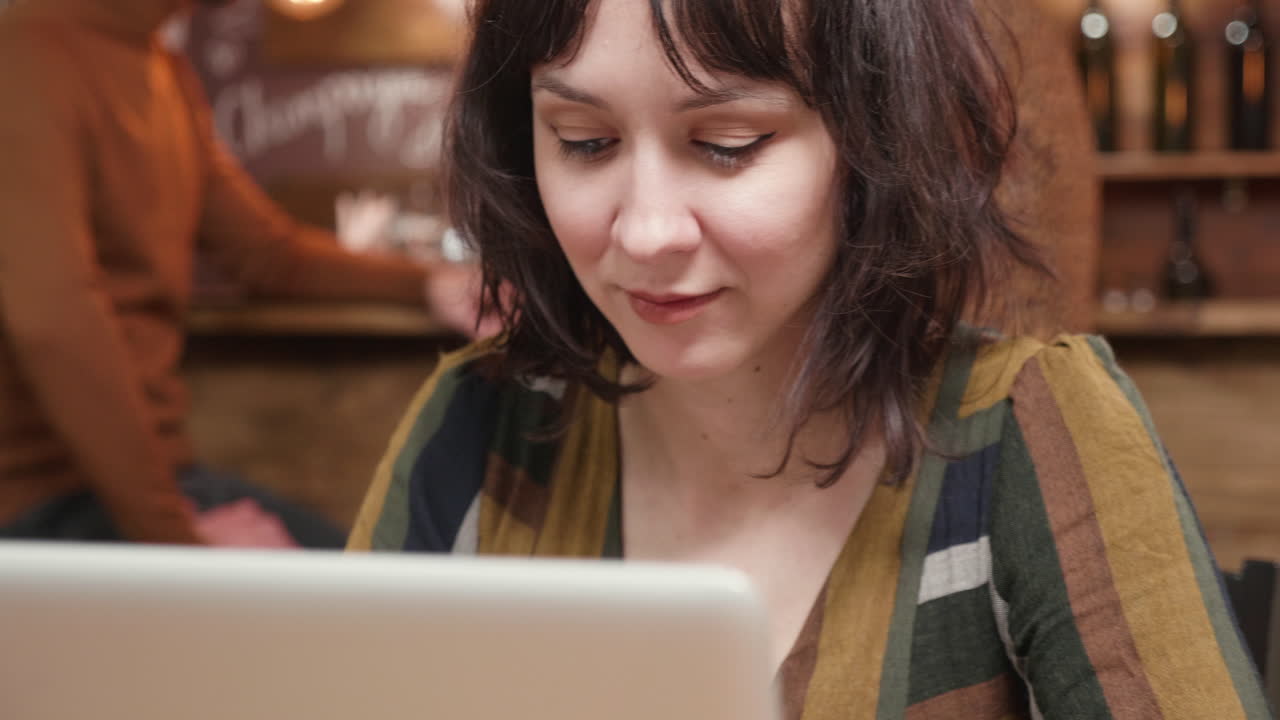 mujer usando una computadora portátil en un café