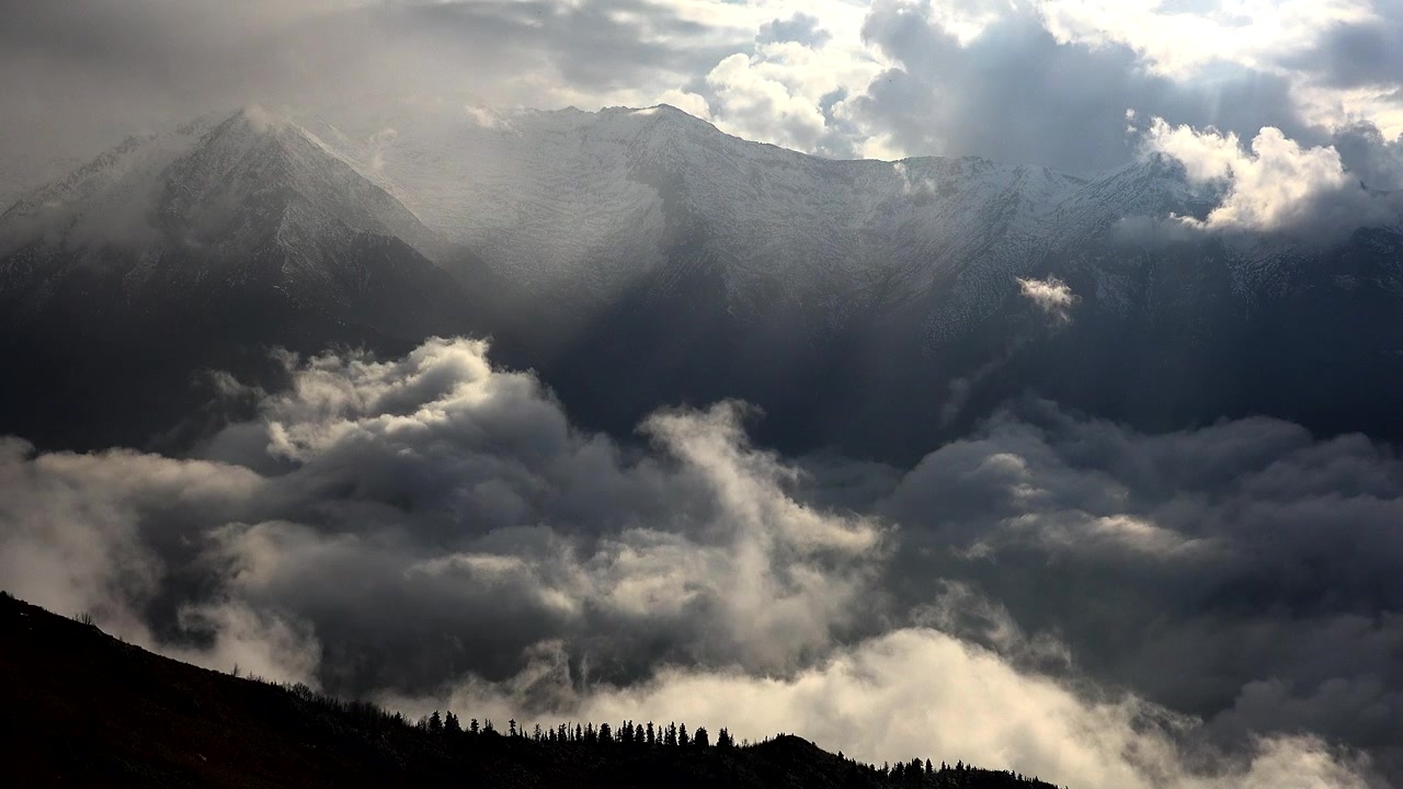 Snow-Capped Mountain Peaks Rising Above a Sea of Clouds