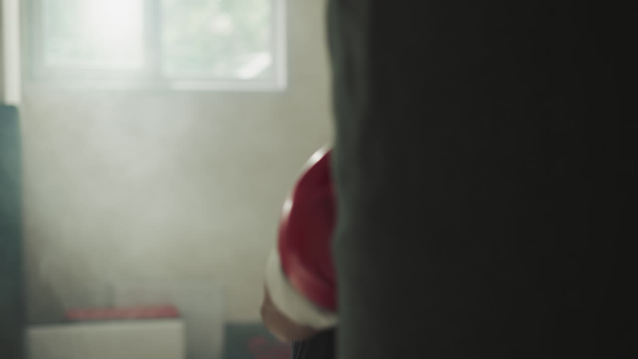 Dynamic man involved in professional boxing striking punching bag in semi-dark gym with equipment. Engaging in sports and releasing pent-up aggression