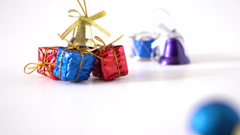 vista de primer plano y foto de estudio panorámico de adornos navideños sobre fondo blanco: cintas doradas, campana, tambor y bola brillante