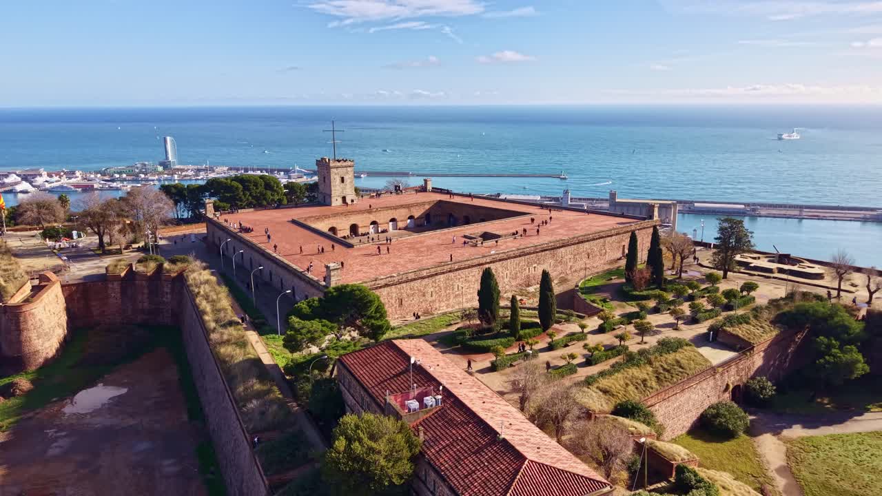 Lo storico Castello di Montjuïc, fortezza militare sulla collina, con vista panoramica sul porto di Barcellona e sul Mar Mediterraneo, Spagna. Vista aerea con drone
