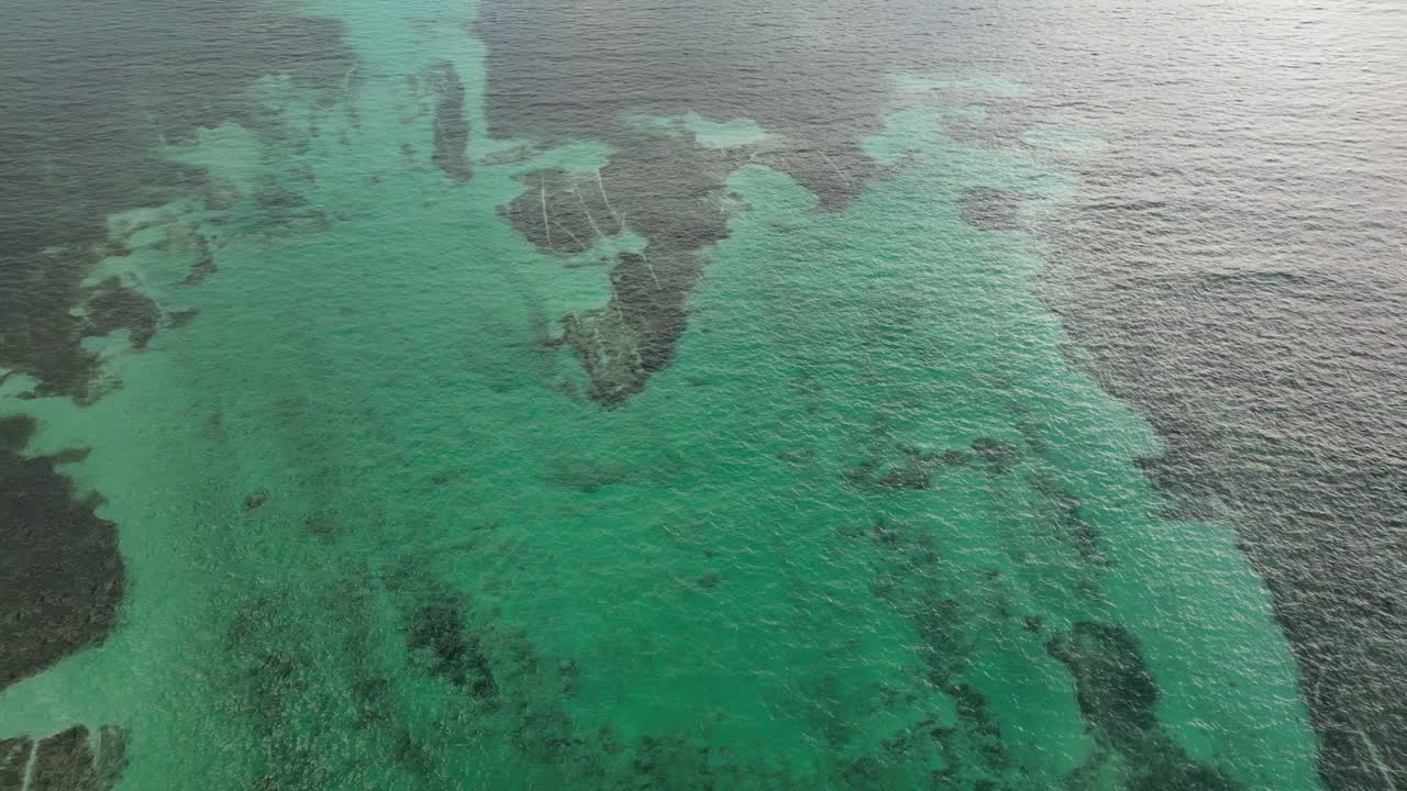 vista de avión no tripulado en belice volando sobre el mar azul oscuro y claro del caribe vista superior del arrecife de coral de aguas poco profundas