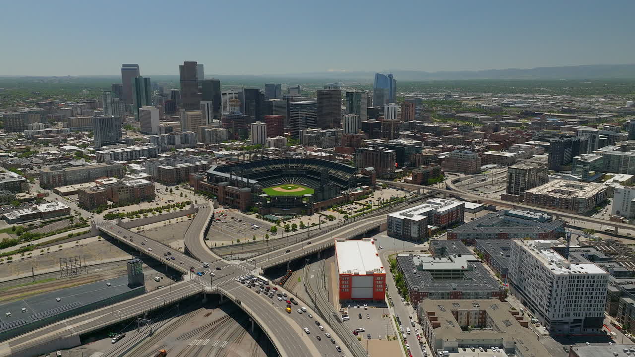 Centro di Denver, stadio di baseball Coors Field dei Colorado Rockies. Paesaggio delle Montagne Rocciose e del Monte Evans. Riprese aeree cinematiche con drone delle colline del Colorado, traffico di auto, treno Amtrak. Primavera, estate, movimento panoramico in avanti.