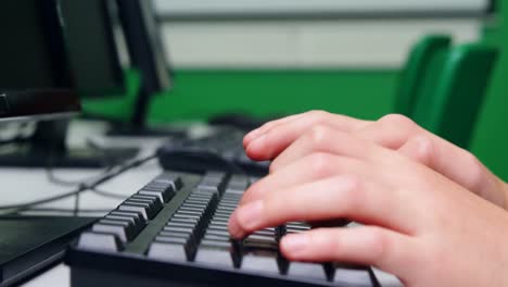 schoolboy studying on computer in classroom