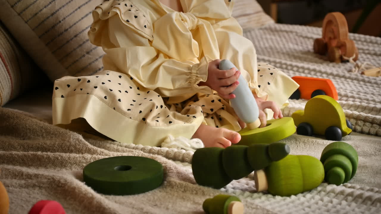 Little girl playing with a wooden poplar tree toy among others ecological toys. Sustainability concept