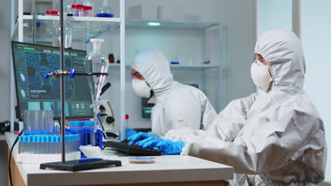 Team-of-biologists-in-coverall-working-with-microscope-and-computer