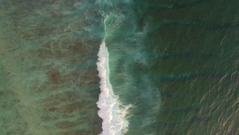 waves breaking over reef aerial shot