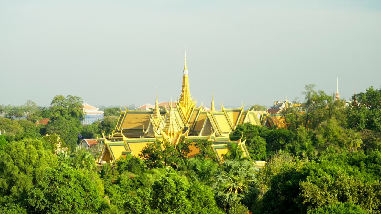 Golden spires of the Royal Palace in Phnom Penh, surrounded by lush greenery