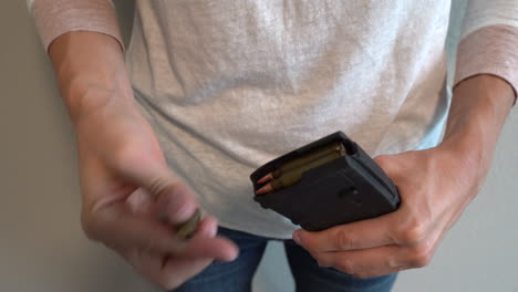 woman loading ar-15 assault weapon magazine with bullets easily