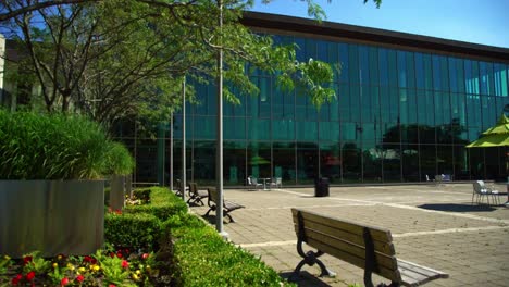 Der-Whitby-Public-Library-Square-Verfügt-über-Holzbänke-Für-Sitzgelegenheiten-Im-Freien-Und-Bietet-Einen-Blick-Von-Außen-Auf-Eine-Moderne-Bibliothek-In-Einer-Kanadischen-Stadt
