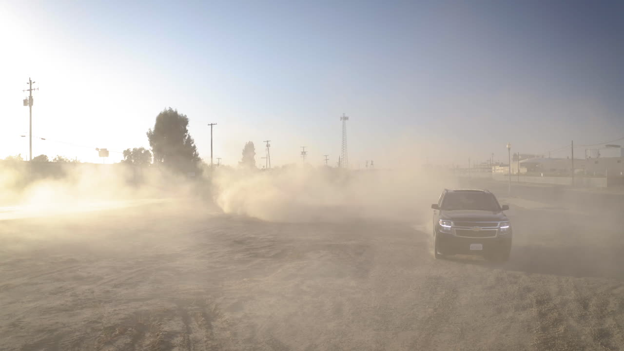 Vehicle Kicking Up a Large Dust Cloud