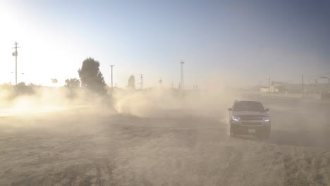 vehicle kicking up a large dust cloud