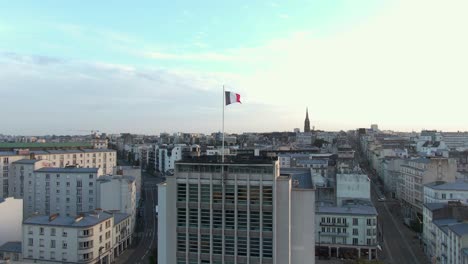 majestic aerial rise ascending waving french flag in city brest