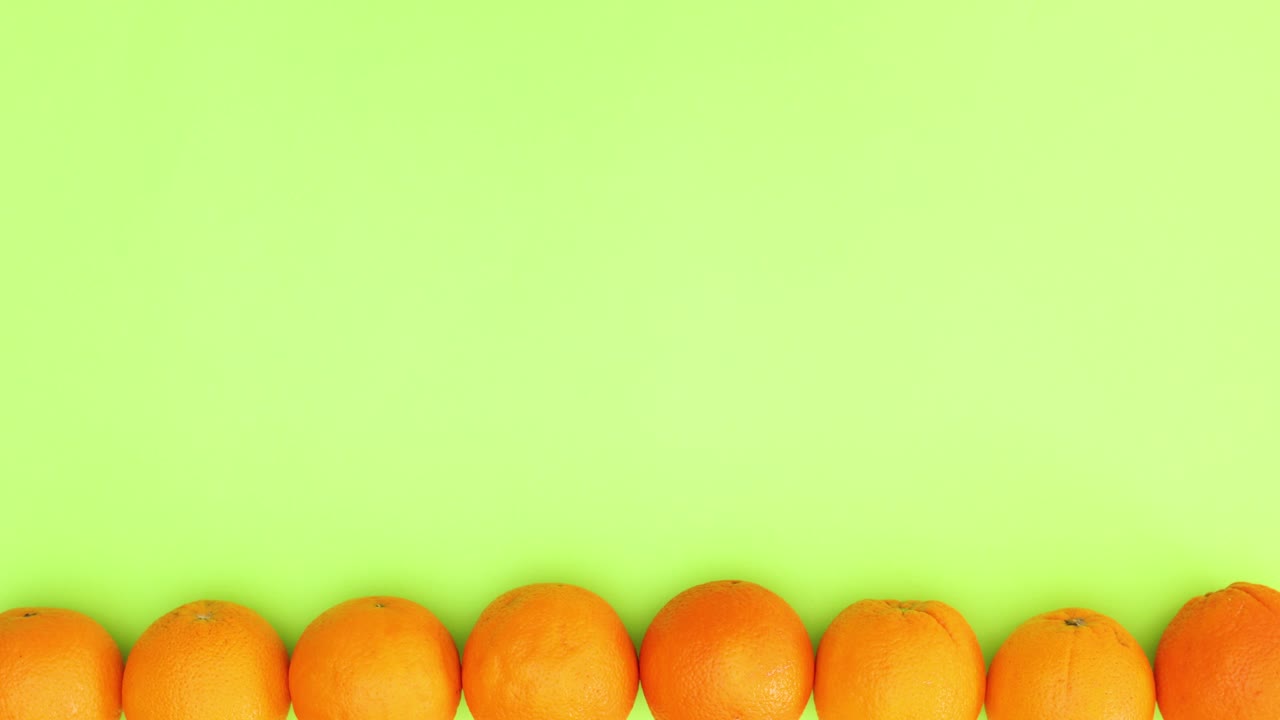 naranjas orgánicas moviéndose en la parte inferior del fondo verde - movimiento de parada