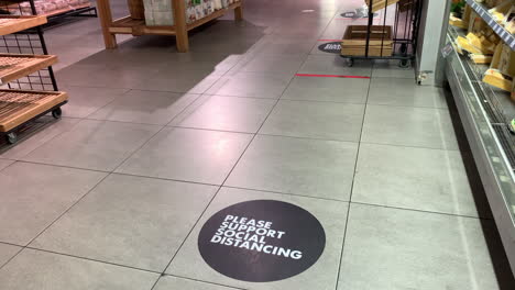 señalización de piso de distanciamiento social en la tienda, toma panorámica alta de derecha a izquierda