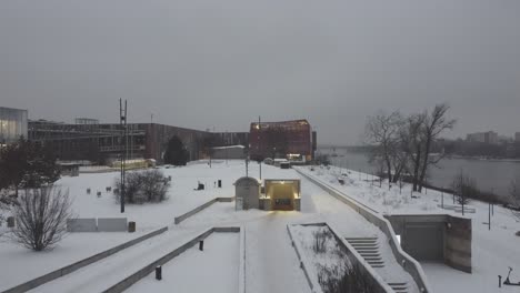 Drone-video-of-a-snowy-riverside-in-warsaw-poland,-next-to-science-museum2